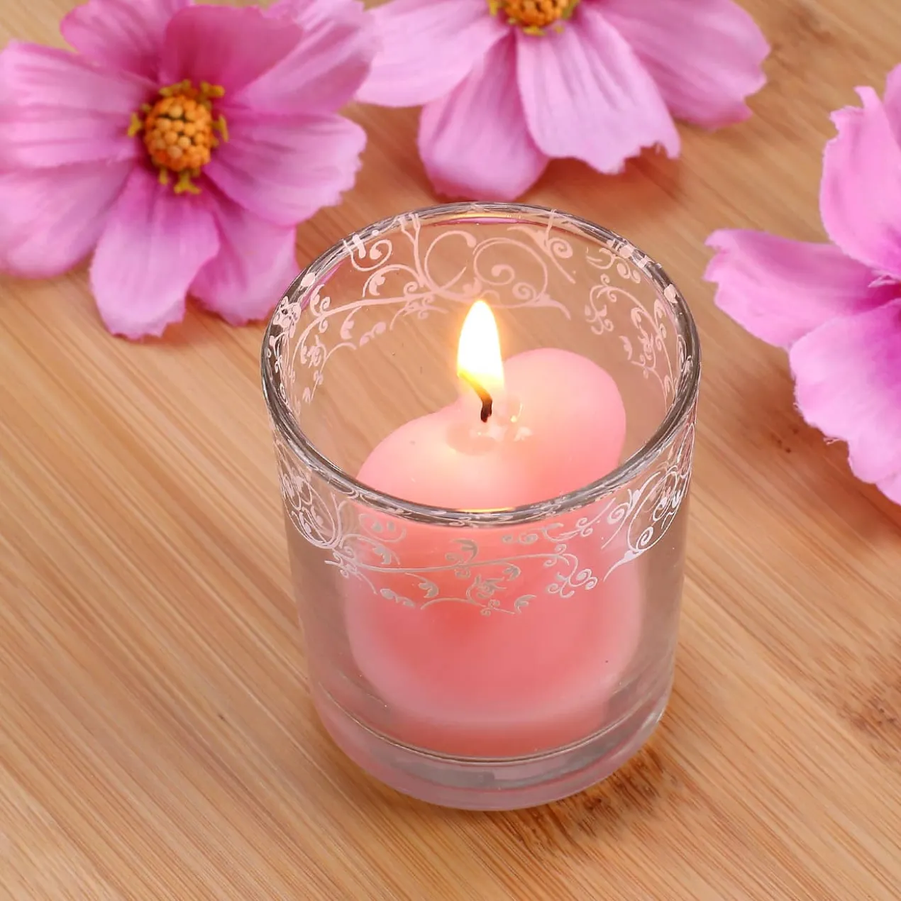 Bezaubernde Herzförmige rosa Kerze im Glas