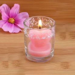 Bezaubernde Herzförmige rosa Kerze im Glas