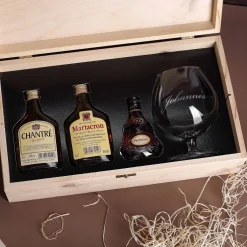 Cognac-Kollektion aus verschiedenen Weinbränden mit Weinbrandglas in gravierter Holzkiste