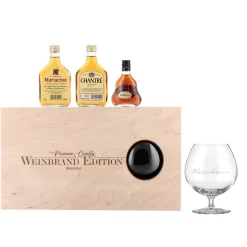 Cognac-Kollektion aus verschiedenen Weinbränden mit Weinbrandglas in gravierter Holzkiste