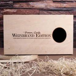 Cognac-Kollektion aus verschiedenen Weinbränden mit Weinbrandglas in gravierter Holzkiste