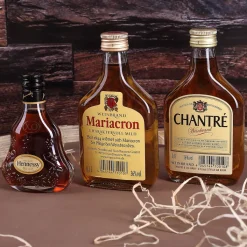 Cognac-Kollektion aus verschiedenen Weinbränden mit Weinbrandglas in gravierter Holzkiste