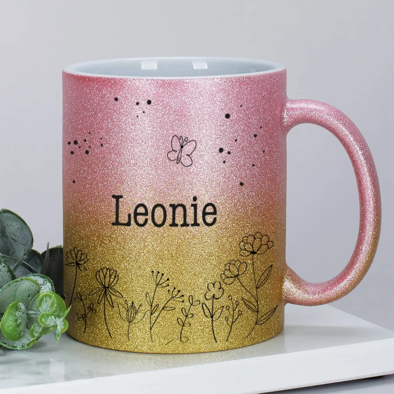 Glitzertasse mit Blumenwiese und Ihrem Wunschnamen bedruckt