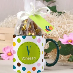 Tasse mit bunten Punkten und Schokoladenkugeln