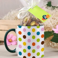 Tasse mit bunten Punkten und Schokoladenkugeln