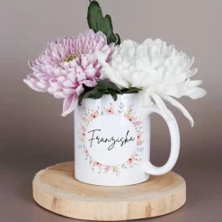 Weiße Keramiktasse mit Namensaufdruck und Blumenmotiv